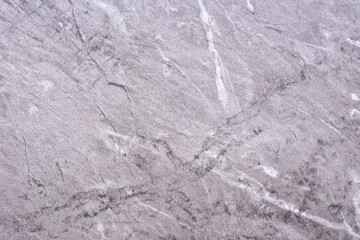 Light gray granite, polished natural stone surface with white and black veins, close-up.