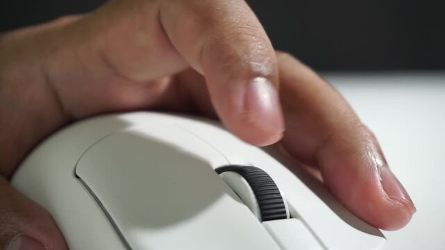 Scrolling action on white computer mouse, finger movement in focus, showing smooth control and usability, macro tech detail in clean setup.