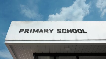 A Primary School word sign displayed on an educational institution building under a clear blue sky, symbolizing elementary education, childhood learning, community, and foundational knowledge
