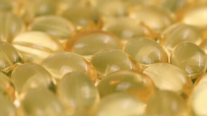 golden transparent vitamin capsules with fish oil, omega-3, and vitamin d supplements rotating in close-up view. nutritional supplements and medication for healthy lifestyle. - Powered by Adobe