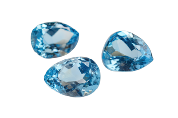 Three pear-shaped faceted blue topaz gemstones isolated on a white background, showcasing their brilliant cut and clarity.
