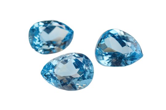 Three pear-shaped faceted blue topaz gemstones isolated on a white background, showcasing their brilliant cut and clarity.