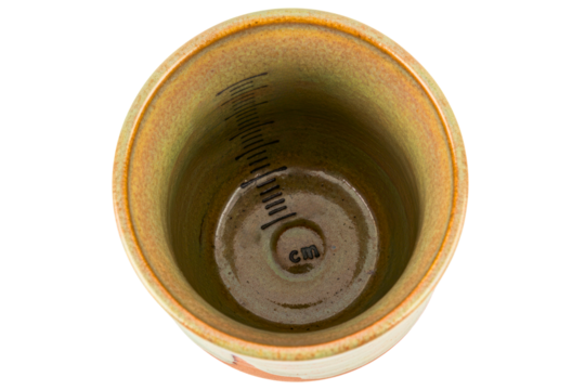 Top view of handmade ceramic cup with measuring marks inside isolated on a transparent background