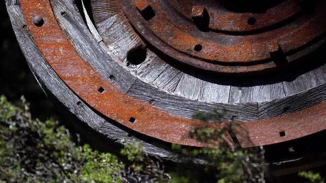 Close-up of a large rusted iron and timber wheel from historic mining machinery in Tasmania. 