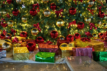 Christmas tree gift boxes holiday ornaments creating a festive display of sparkling red and gold decorations and warm lights