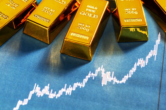 Close-up of gold bars and an upward trend. Gold bars price concept with rising chart.