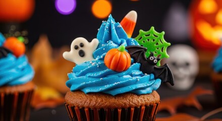 A Halloween cupcake with blue frosting, ghost, pumpkin, and bat decorations.