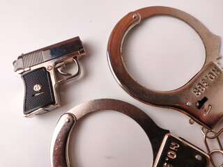 Obraz premium The image shows a toy police set, which includes a pair of toy handcuffs and a toy gun