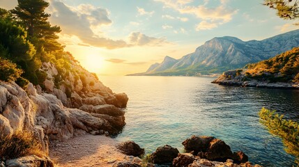 A stunning sunset over a calm, turquoise sea with rocky cliffs and lush vegetation.