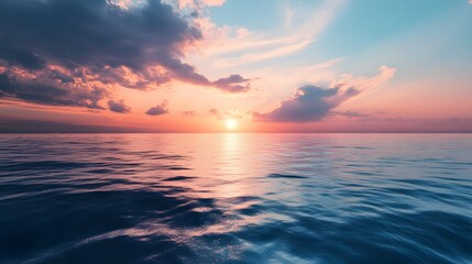 Obraz premium A vibrant sunset over a calm ocean with soft, pink, and orange hues reflecting on the water.