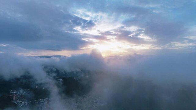 ea of Clouds Blanketing a Small Mountain City in China, Illuminated by Evening Glow