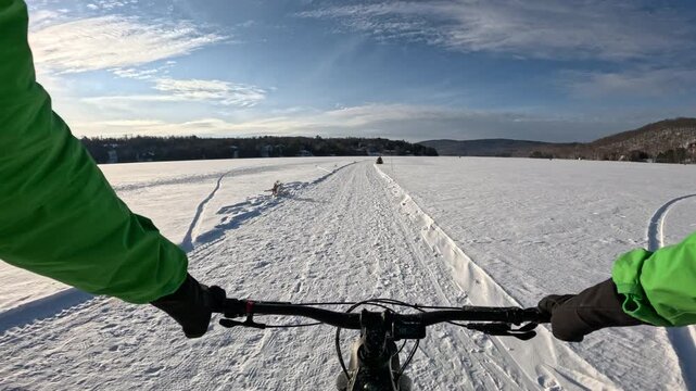 Winter Wonderland. Fat Biking Across a Frozen Lake - Scenic Adventure Cycling Experience. Exploring Frozen Lake Trails on a Fat Bike - Thrilling Winter Ride in Snowy Landscape.