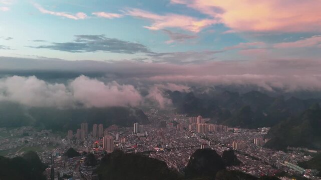 ea of Clouds Blanketing a Small Mountain City in China, Illuminated by Evening Glow