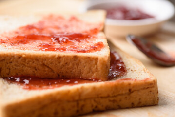 Strawberry jam for a classic breakfast on wooden background