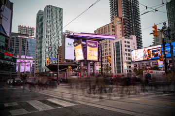Fototapeta premium View of Sankofa Square (Yonge-Dundas) with motion blur of people in Toronto. Toronto, Canada - October 17, 2025.