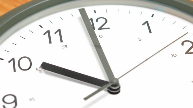 4K Close-up view of a round wall clock showing the time at exactly 10:00 with sharp black hands against a clean white face.