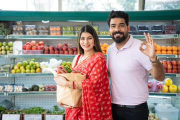 Indian couple purchasing vegetables at super shop.
