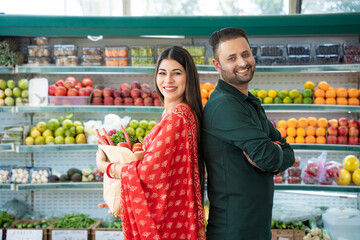 Indian couple purchasing vegetables at super shop.