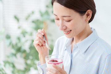 朝食にヨーグルトを食べる女性