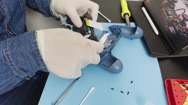 Electronic technician repairing broken video game controller