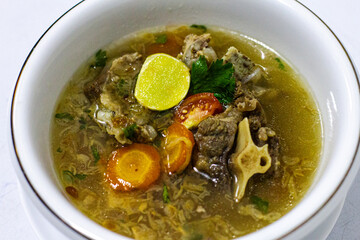 Detailed Special Oxtail Soup Sop Buntut Indonesian Food with Spices, Carrot, Lime, Corriander Close Up Photo