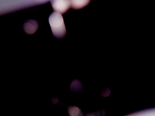 Blurred lights evoke mystery and intrigue with subtle colors against the darkness of the night.