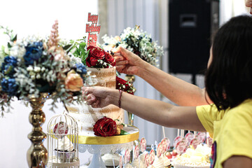 2 hands pointing at a birthday cake with Flower Bouquet, Cupcakes