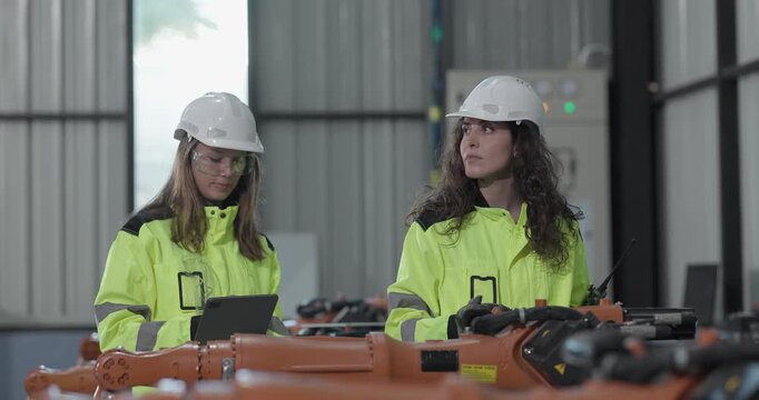 Robotic technicians perform safety maintenance, using a digital clamp meter to measure the current, voltage, resistance, capacity, and temperature of robotic arms inside an industrial facility.
