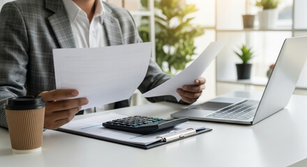 Finance report analyst tax budget financial accounting professional reviewing documents with calculator laptop clipboard and coffee in bright office focusing on paperwork and calculated planning