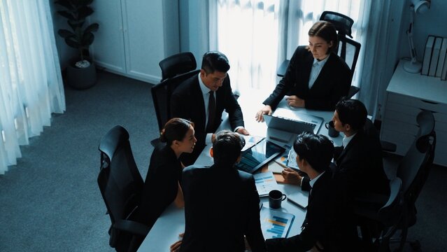 Top view businesspeople placed tablet at table and planning strategy while diverse team discuss about financial plan. Group of diverse team brainstorm marketing idea at meeting table. Directorate.