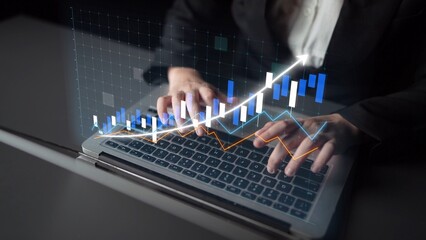 Focused hands typing on a laptop, overlaid with a digital graph symbolizing financial growth and market trends, ideal for business themes and analytics concepts. Copula