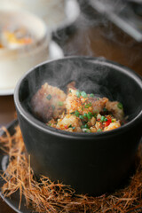 Hot Stir-Fried Seafood Served in Black Bowl with Steam Rising