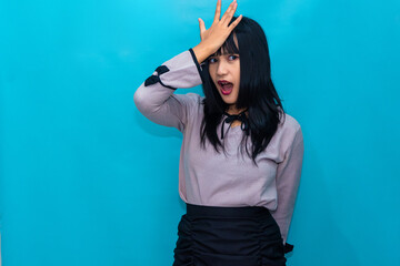 With one hand on her forehead, the woman shows surprise and realization. Ideal for humorous, expressive, and lifestyle visuals.