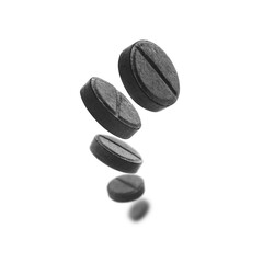 Black activated carbon tablets levitate on a white background