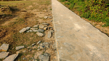 Nature walking track made of stones with grass on both sides