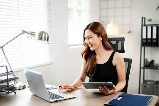 Business woman using tablet and laptop for doing math finance on an office desk, tax, report, accounting, statistics, and analytical research concept in office