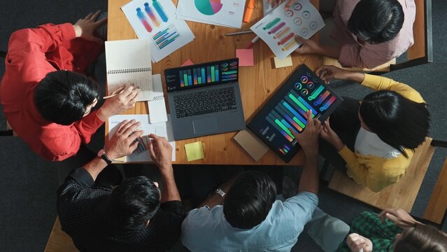 Top view of business team looking at laptop and analyzing chart. Close up of diverse group working on computer and reading financial report. Group of people explain idea at meeting. Convocation. - Powered by Adobe