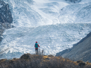 Backpacking woman hiking on winter high altitude mountain top