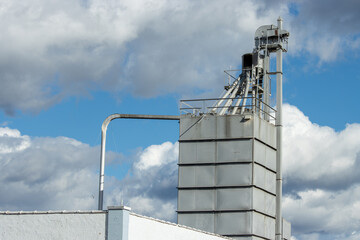 Feed mill equipment against a cloudy sky