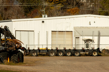 A flatbed semi-trailer by a warehouse