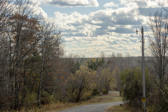A rural paved road in the countryside during autumn - Powered by Adobe
