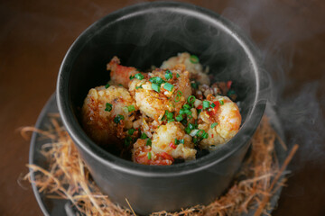 Hot Stir-Fried Seafood Served in Black Bowl with Steam Rising