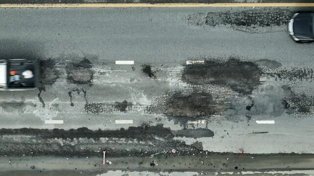 From above, cracks and damage on the asphalt surface highlight issues of neglect, road safety risks, inefficient urban management, environmental stress, maintenance challenges, aging infrastructure.
