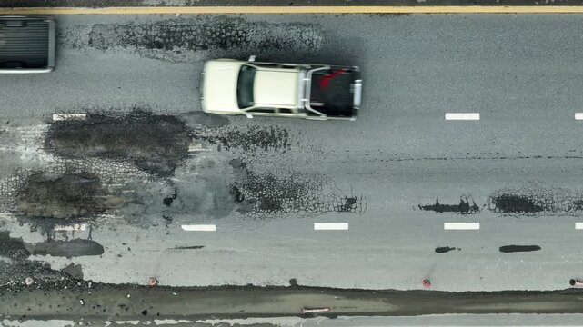 Severe asphalt deterioration, seen from above, underlines the results of insufficient maintenance, rising hazards, poor city planning, environmental wear, and the importance of immediate action.
