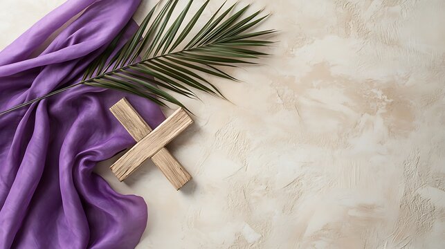 Purple fabric and palm frond with wooden cross on textured background