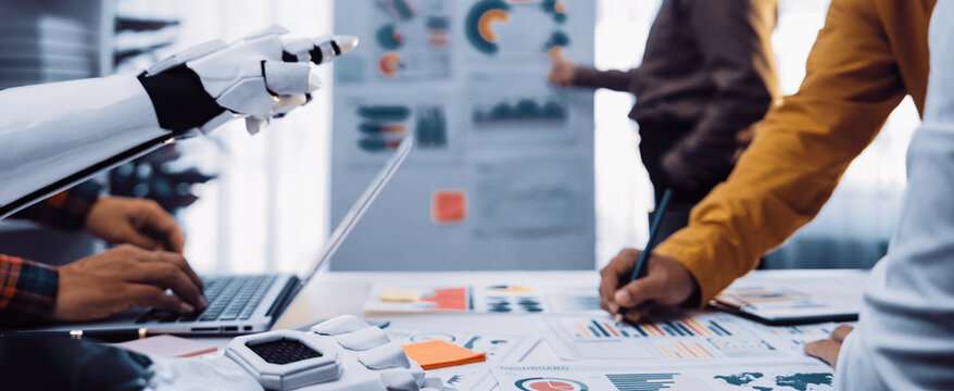 A modern office scene displaying collaboration between humans and robots with data visualization elements, emphasizing technology integration for effective business strategies.Noogenesis - Powered by Adobe