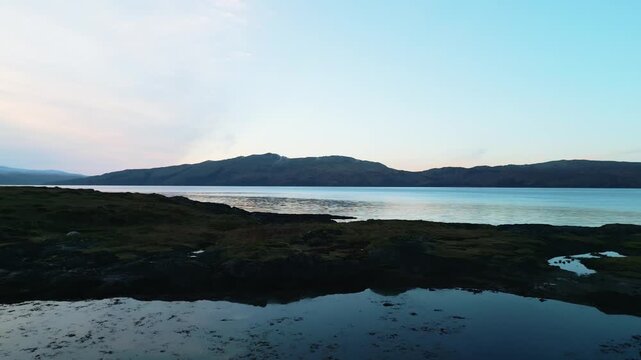 Aerial Drone Footage of a Seaside Bothy on a Scottish Loch, Isle of Lismore &mdash; Remote Stone Shelter, Rugged Coastline, Calm Water Reflections, and Dramatic Highlands Landscape in Soft Natural Light