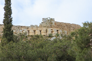 Fototapeta premium Ancient marble ruins of the Acropolis in Athens, Greece. Historic temple remains surrounded by greenery. Archaeology and classical heritage concept