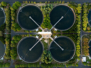 Aerial view of circular water treatment tanks, surrounded by greenery