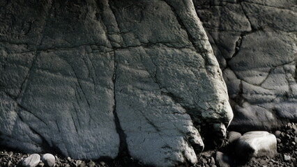 Striking patterns on weathered rock create a captivating scene along the coastline during twilight. The soft light highlights the textures, enhancing the beauty of nature.